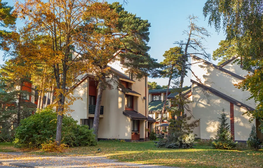 Rudenėjantys medžiai prieš viešbučio korpusus