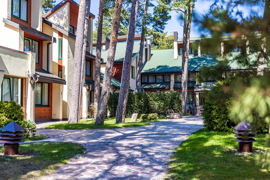 Grįstas takas tarp korpusų su žaliais stogais
