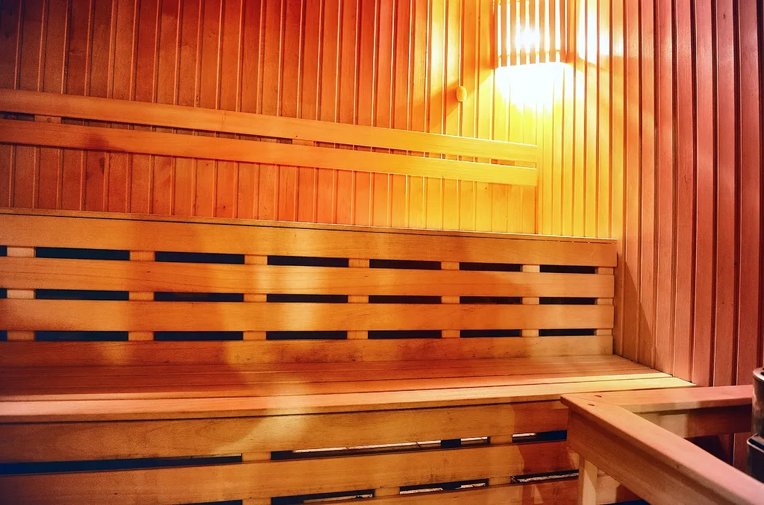 Medinė sauna su gultais ir šviestuvu prie sienos